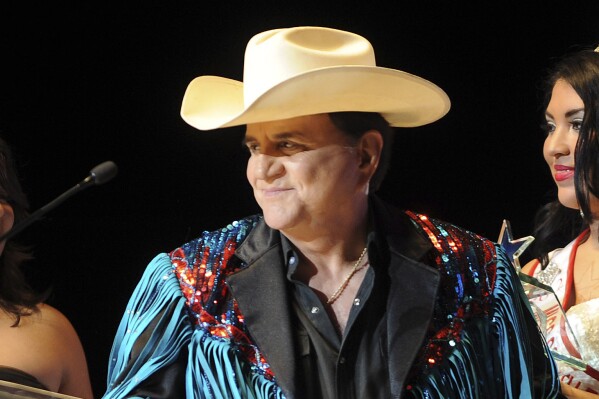 Johnny Canales, host of the "Johnny Canales Show" is honored with a lifetime achievement recognition during the Tejano Music Awards in San Antonio, Texas on Aug. 18, 2012. Canales has died, according to a statement from his family. He was 77. (Billy Calzada/The San Antonio Express-News via AP)