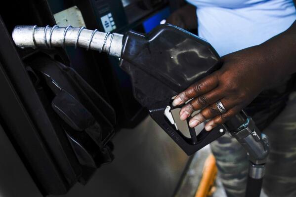 Delores Bledsoe, of Houston, Texas, replaces the nozzle after fueling up her rig at a truck stop in Carlisle, Pa., Wednesday, July 13, 2022. (AP Photo/Matt Rourke)