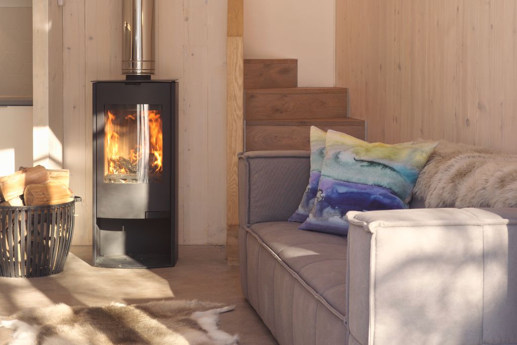 Comfy sofa in the living space at The Woodshed in Penicuik, Midlothian with real wood-burner and logs next to the fire