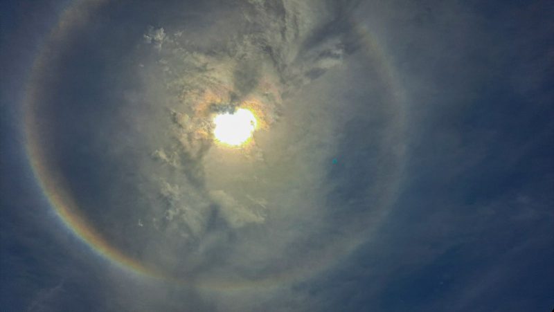 Cloudy and hazy sky with halo around the sun.