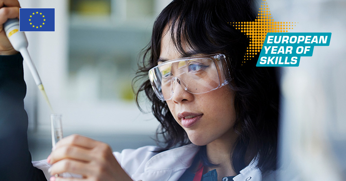 Woman in protective glasses looking at a test tube