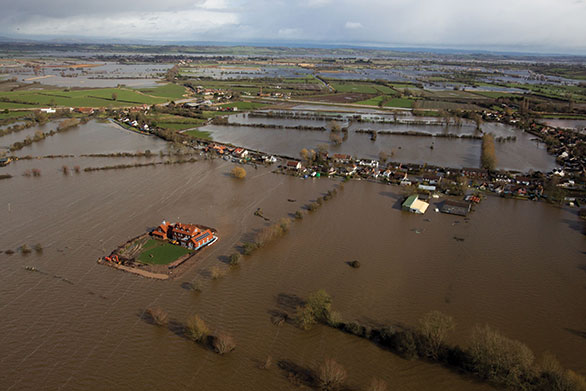 A house (left) near flooded village of Moorland in Somerset which is owned by Sam Notaro and who has built his own flood defences. Thursday February 13, 2014