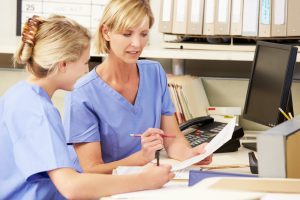 Nurses in a meeting. Keywords: reflection, supervision, meeting, discussion, management, appraisal, paperwork, nurses talking, general practice, primary care