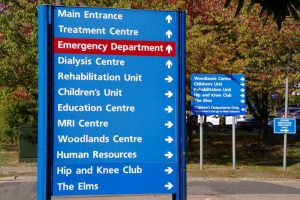 A sign outside a hospital showing various different departments