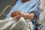 Stock image of a hospital patient receiving a peripheral IV