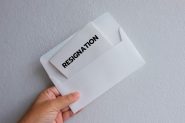 Stock image of a hand holding a letter with the word 'resignation' on it