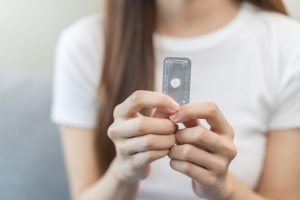 Woman holding emergency oral contraception.