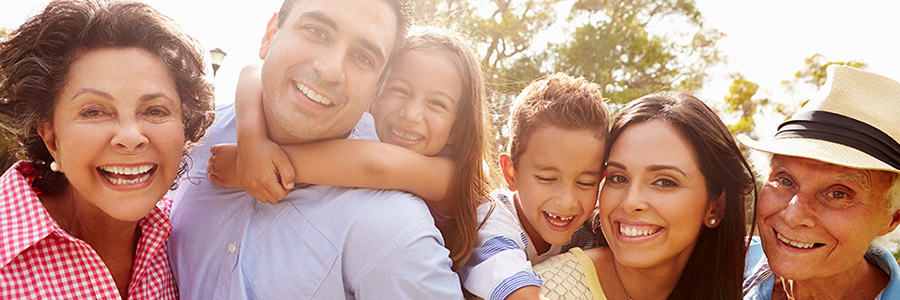 smiling multigenerational family consisting of grandmother, father, daughter, son, mother, and grandfather