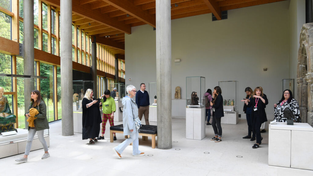 People walk through a room with sculptures