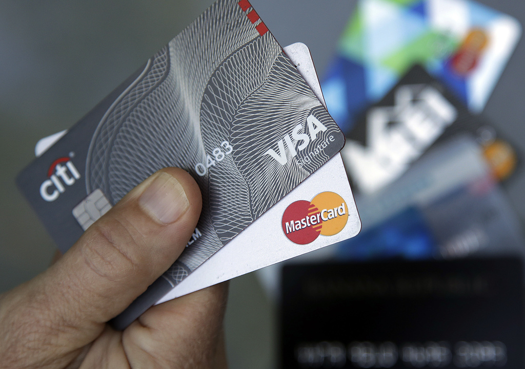 A person holds two Visa and Mastercard credit cards.