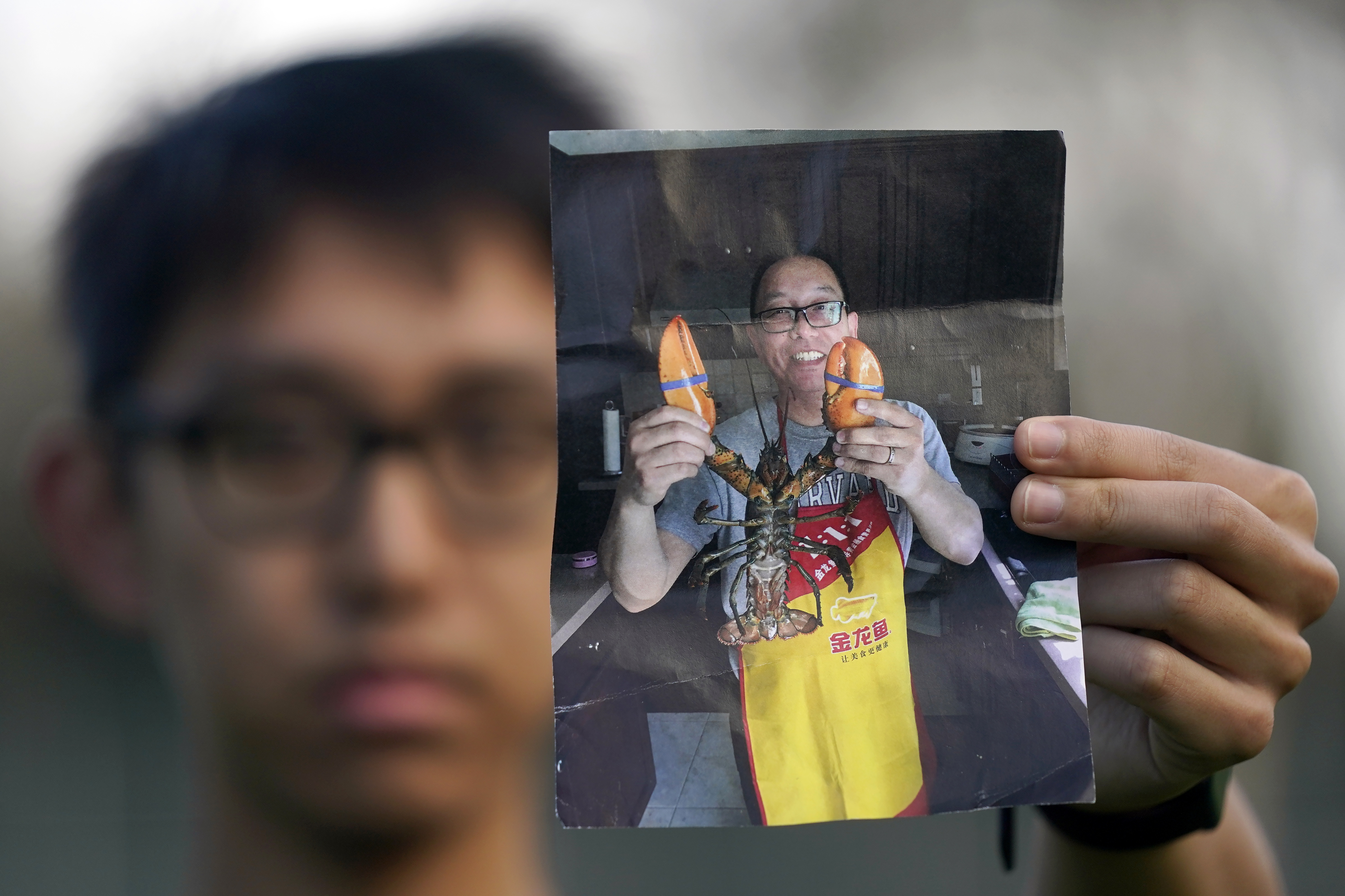 Harrison Li holds a photo of his father, Kai Li