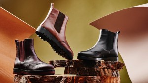 Black and brown leather chelsea boots made of genuine leather in classic style on a wooden cut. Close-up. High quality photo