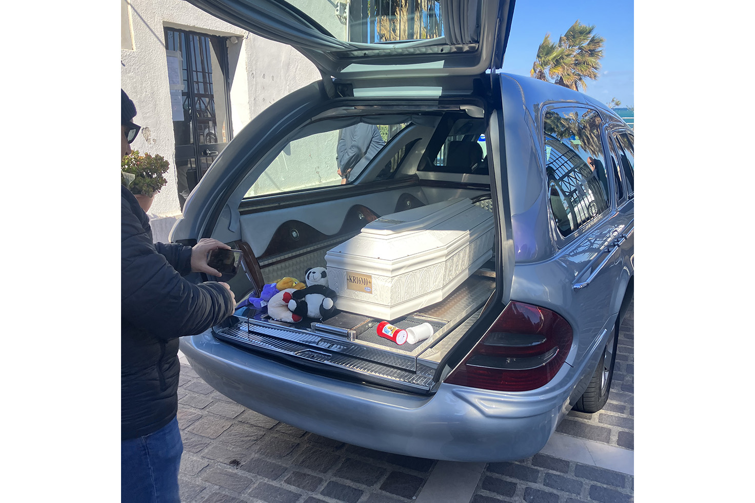 The small white coffin of a young victim of the Italy migrant boat accident rests in the back of a hearse at the graveyard near the beach in Crotone, Italy.