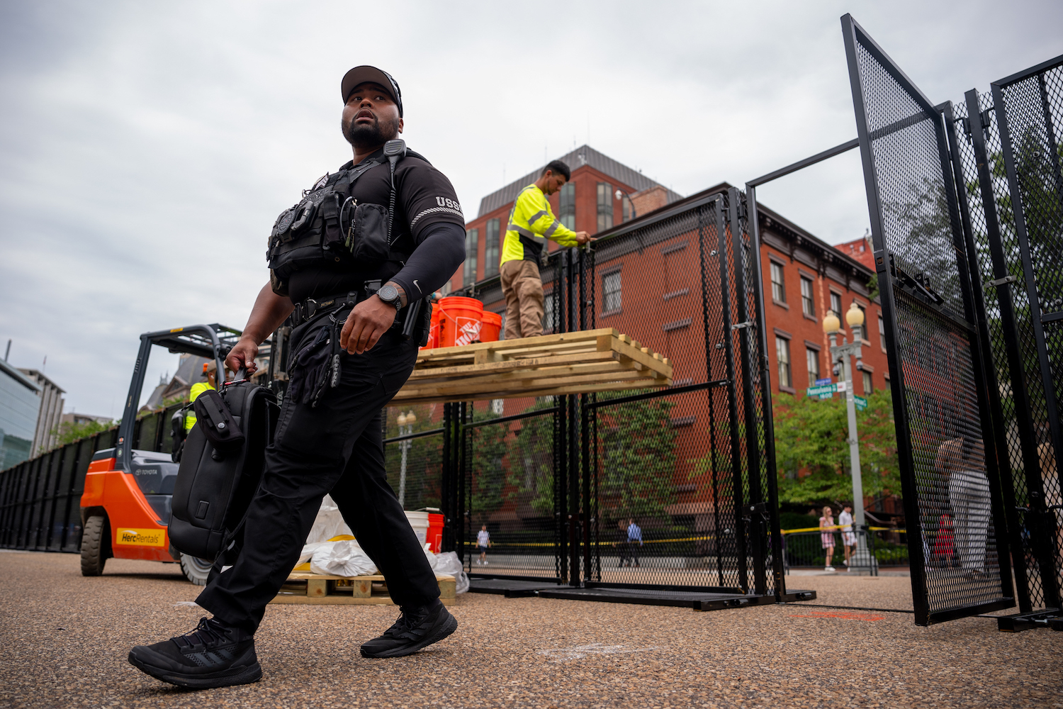 A U.S. Secret Service member walks past workers as they put up additional security fencing around the White House ahead of Israeli Prime Minister Benjamin Netanyahu's visit with U.S. President Joe Biden in Washington on July 24.