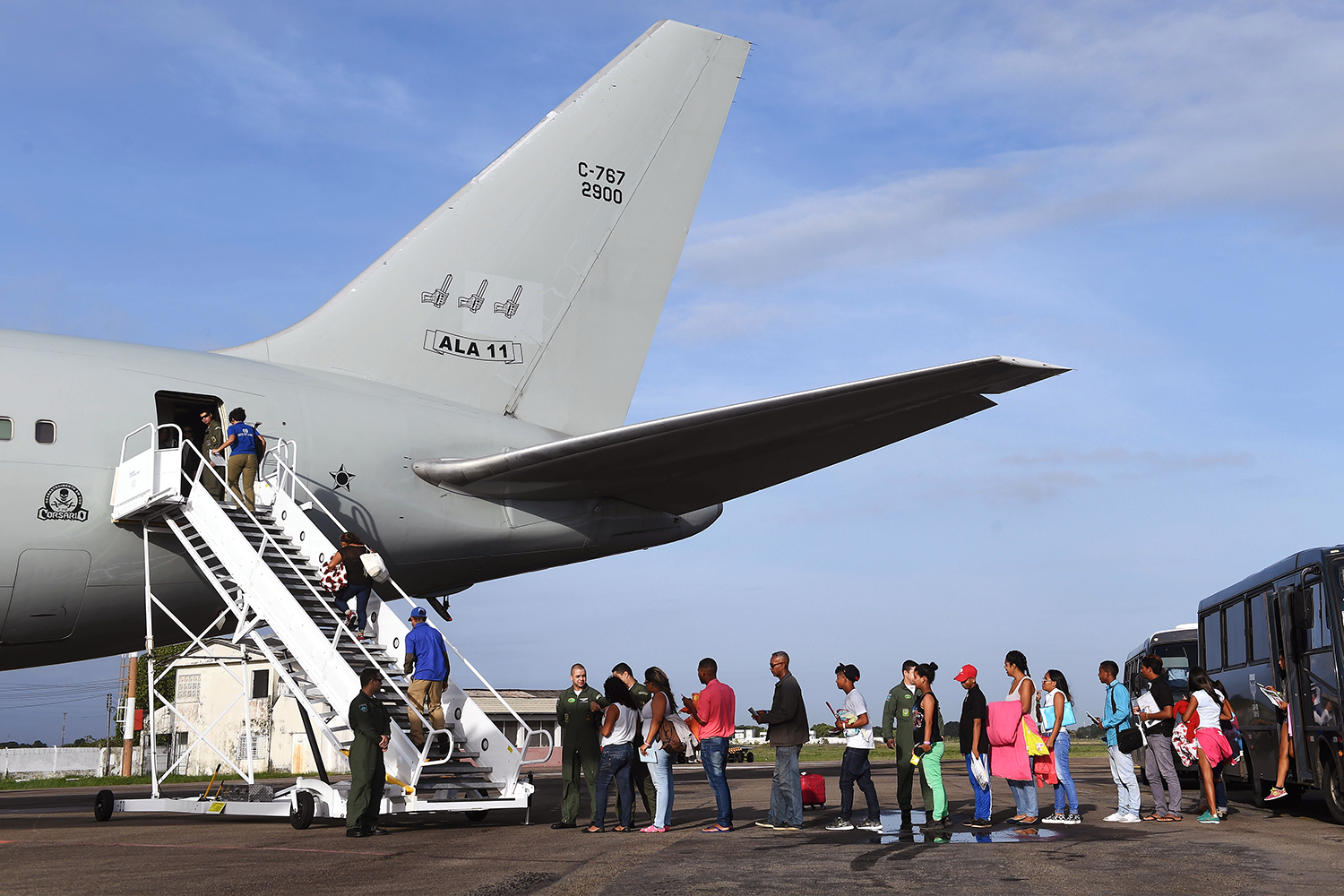 A line of Venezuelan refugees board a Brazilian Air Force plane.