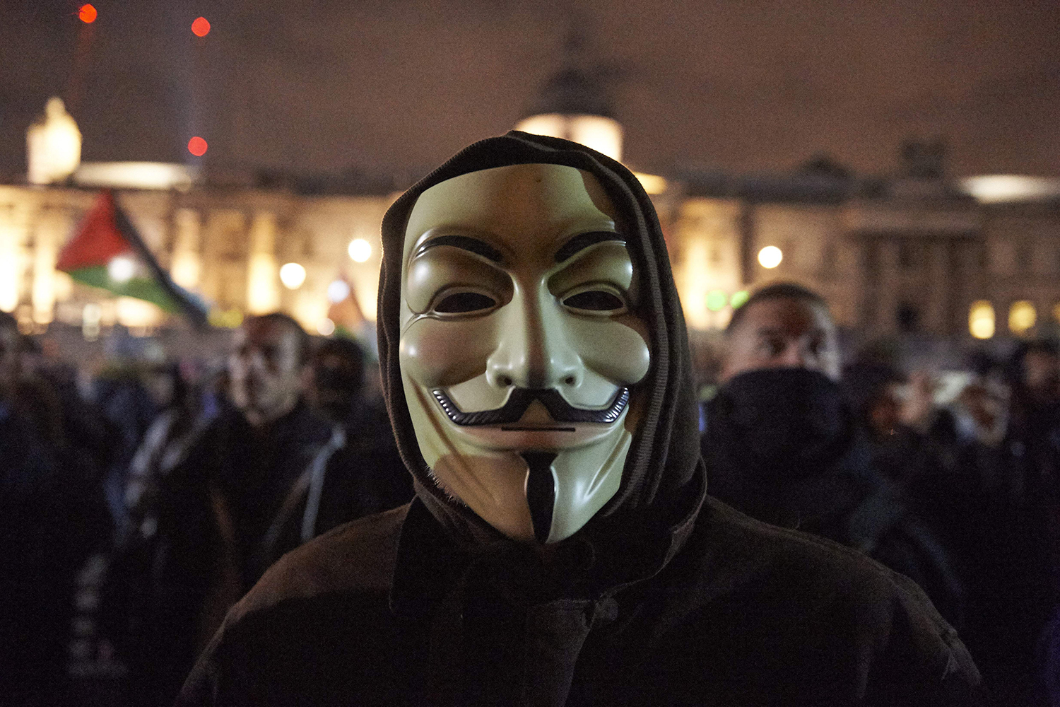 Demonstrators gather in Trafalgar Square during the Million Mask March while wearing Guy Fawkes masks.