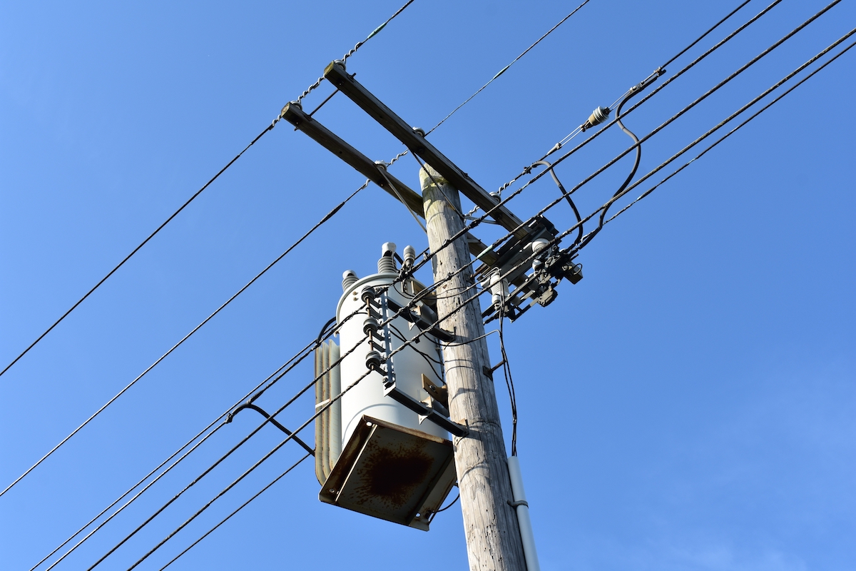 powerlines and a transformer in a blue sky