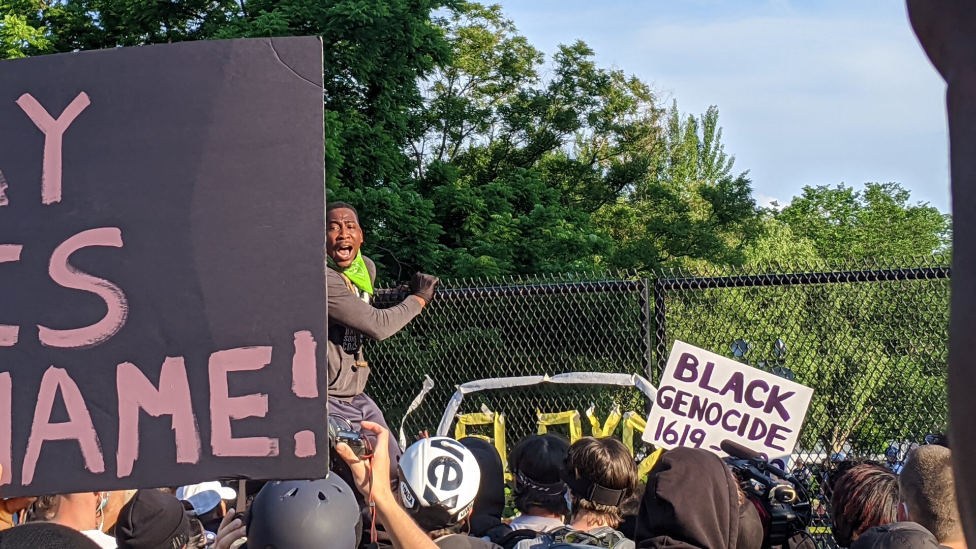 A protester scales a fence at the White House—to urge the rest of the crowd to refrain from shaking it.