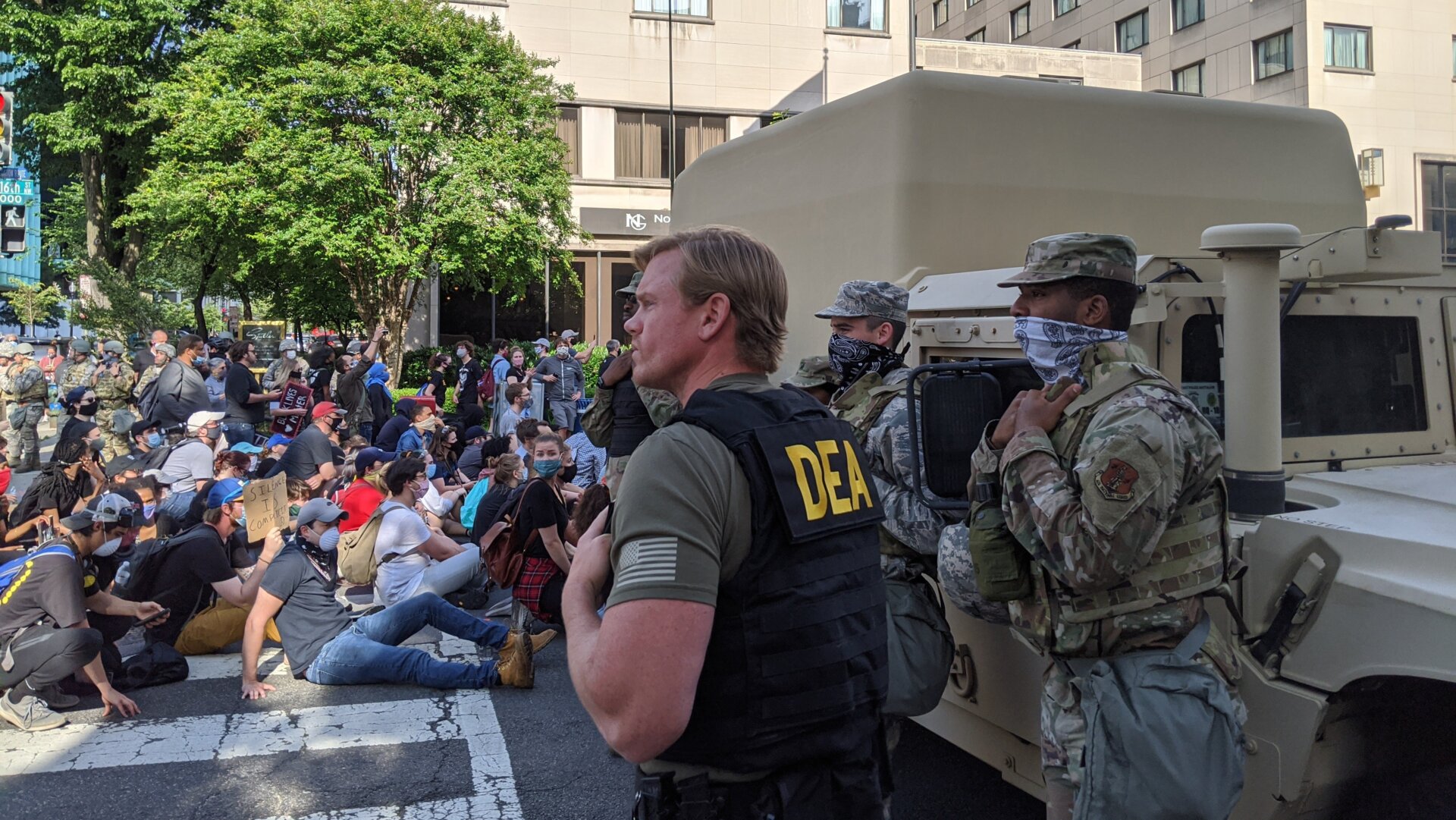 A DEA agent confers with several soldiers as protesters march to the White House on June 2.