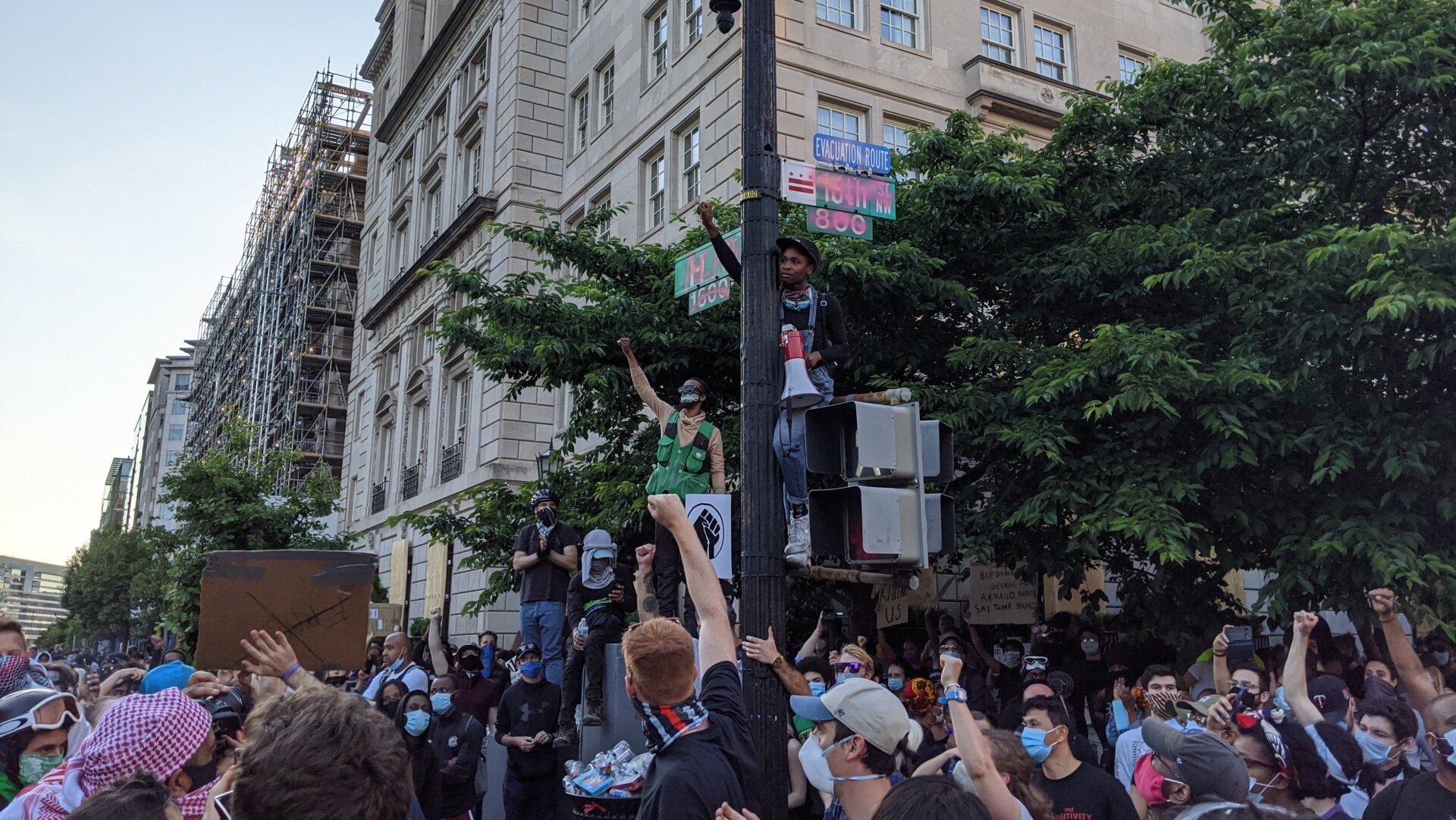 Protest organizers scale a stoplight outside LaFayette Square in DC on June 2.