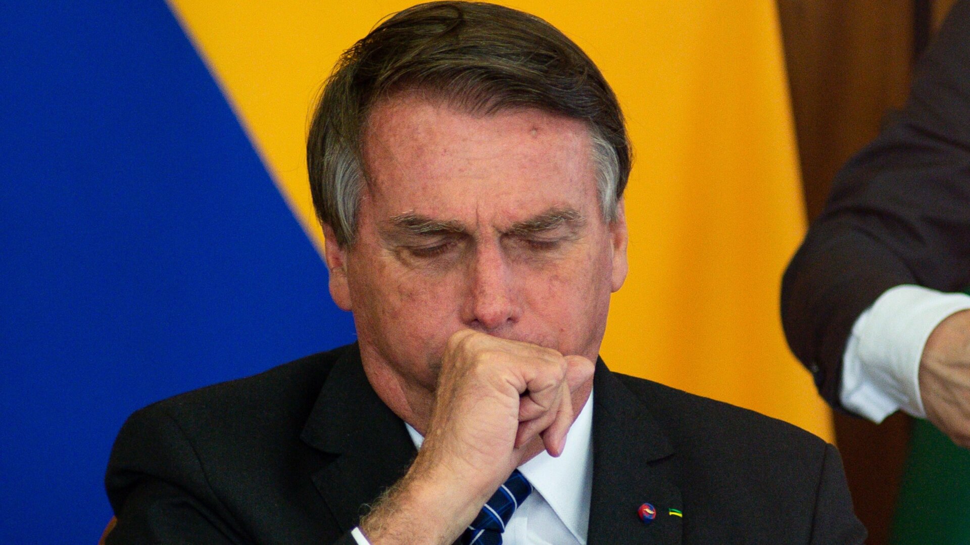 Jair Bolsonaro coughs during a press conference with Colombian President Ivan Duque at Planalto Palace on Oct. 19, 2021 in Brasilia.