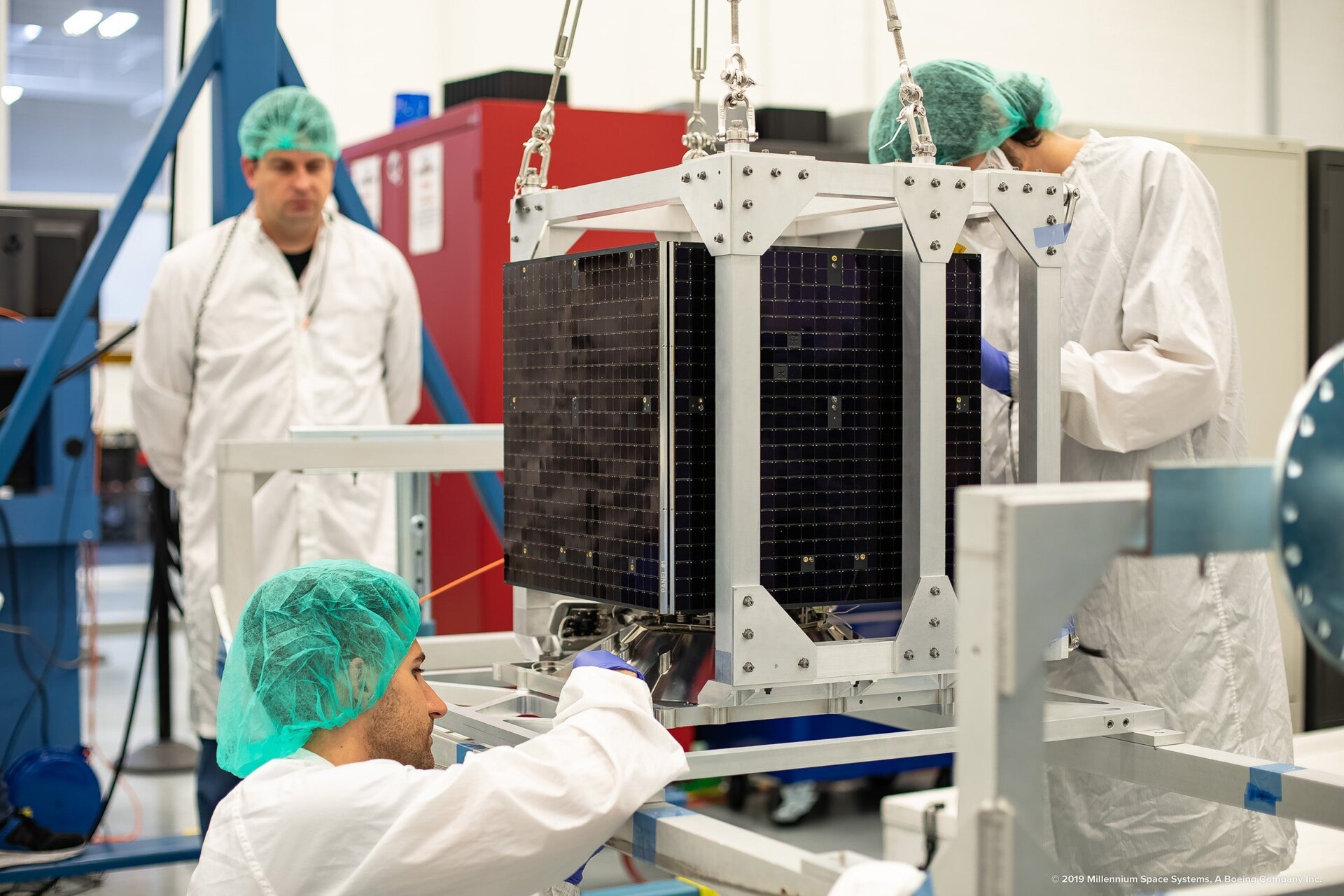 Technicians inspecting the TETRA-1 satellite. 