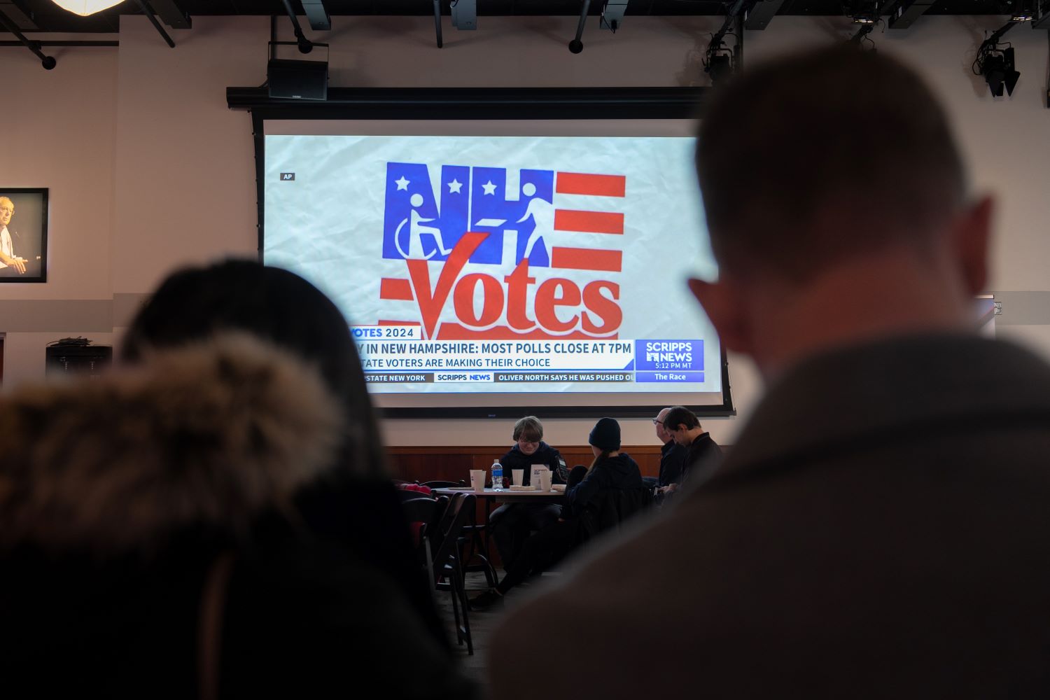 A television screen in a polling station with a logo saying "NH Votes."