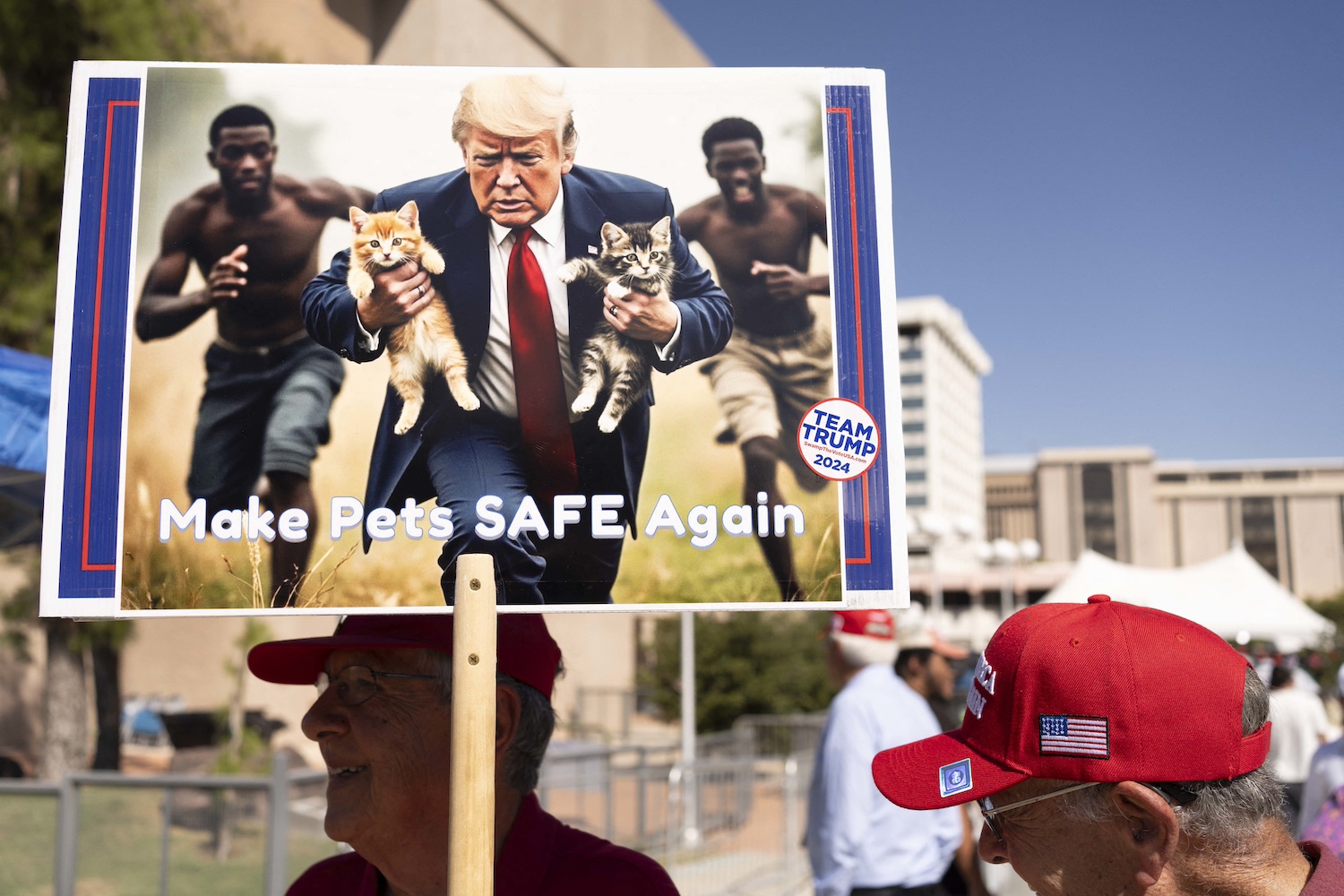 A man carrying a sign with an AI-generated image of Donald Trump rescuing cats