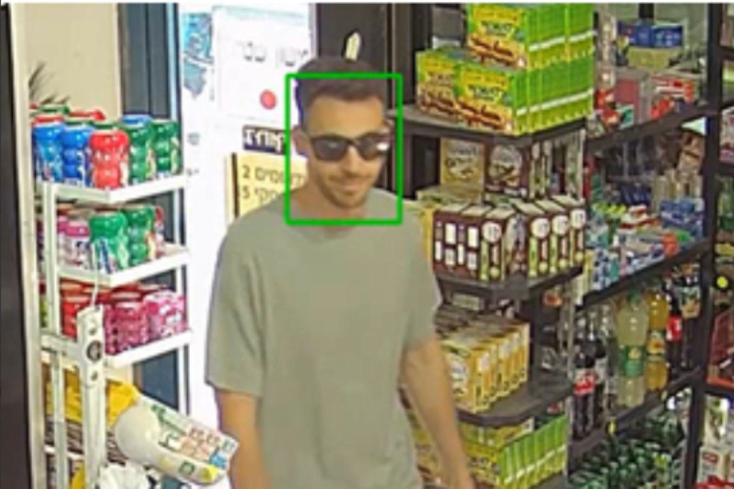 A man in sunglasses walking into a store with a green facial recognition bounding box around his head.