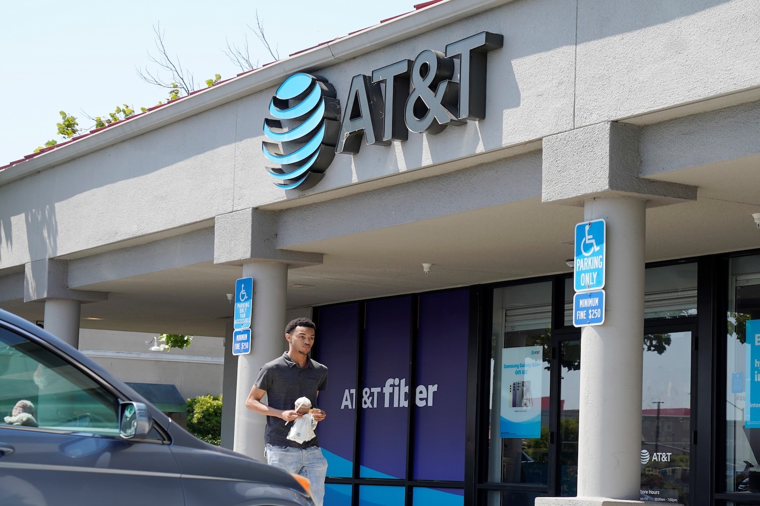 A man walks in front of an AT&T retail store.