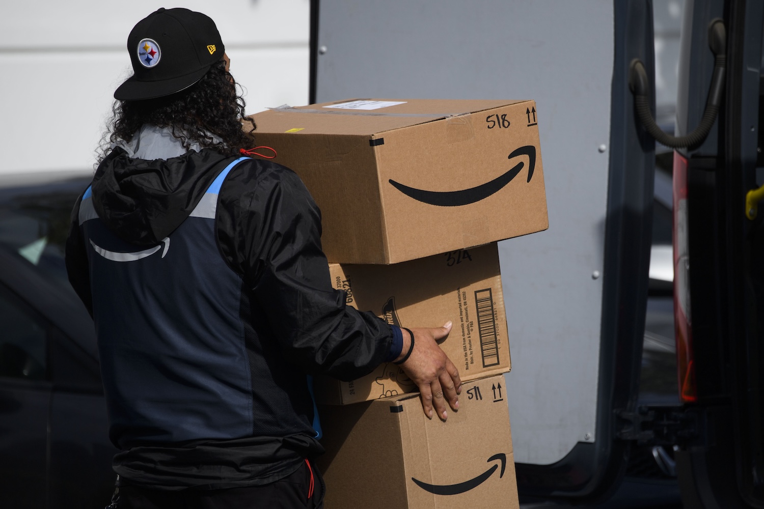 Amazon delivery driver holding packages.