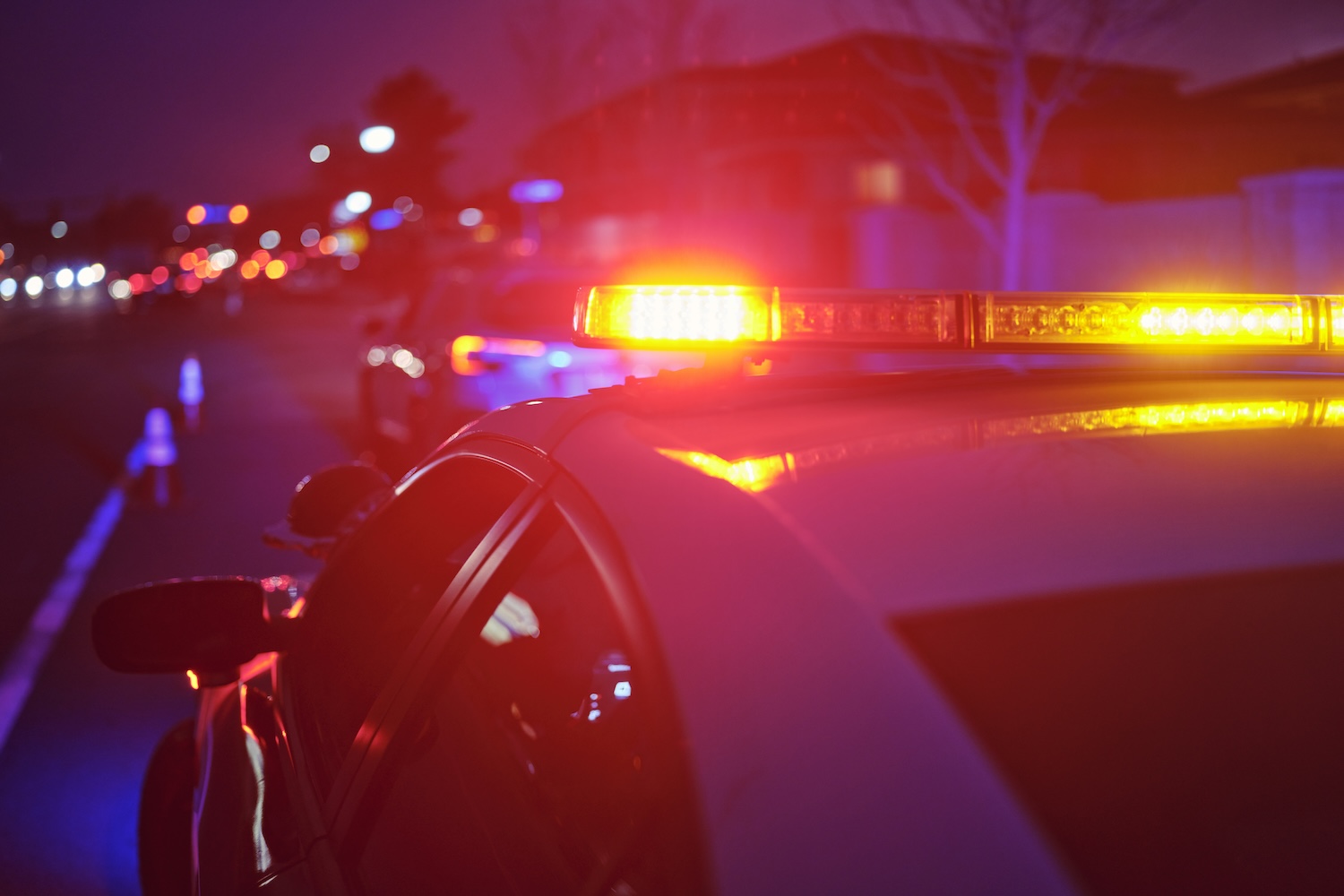 Police squad car at night with lights on.