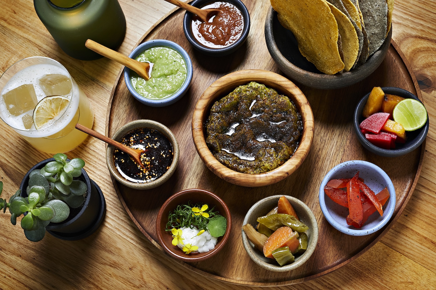 Overhead shot of salsas and peppers on a table.