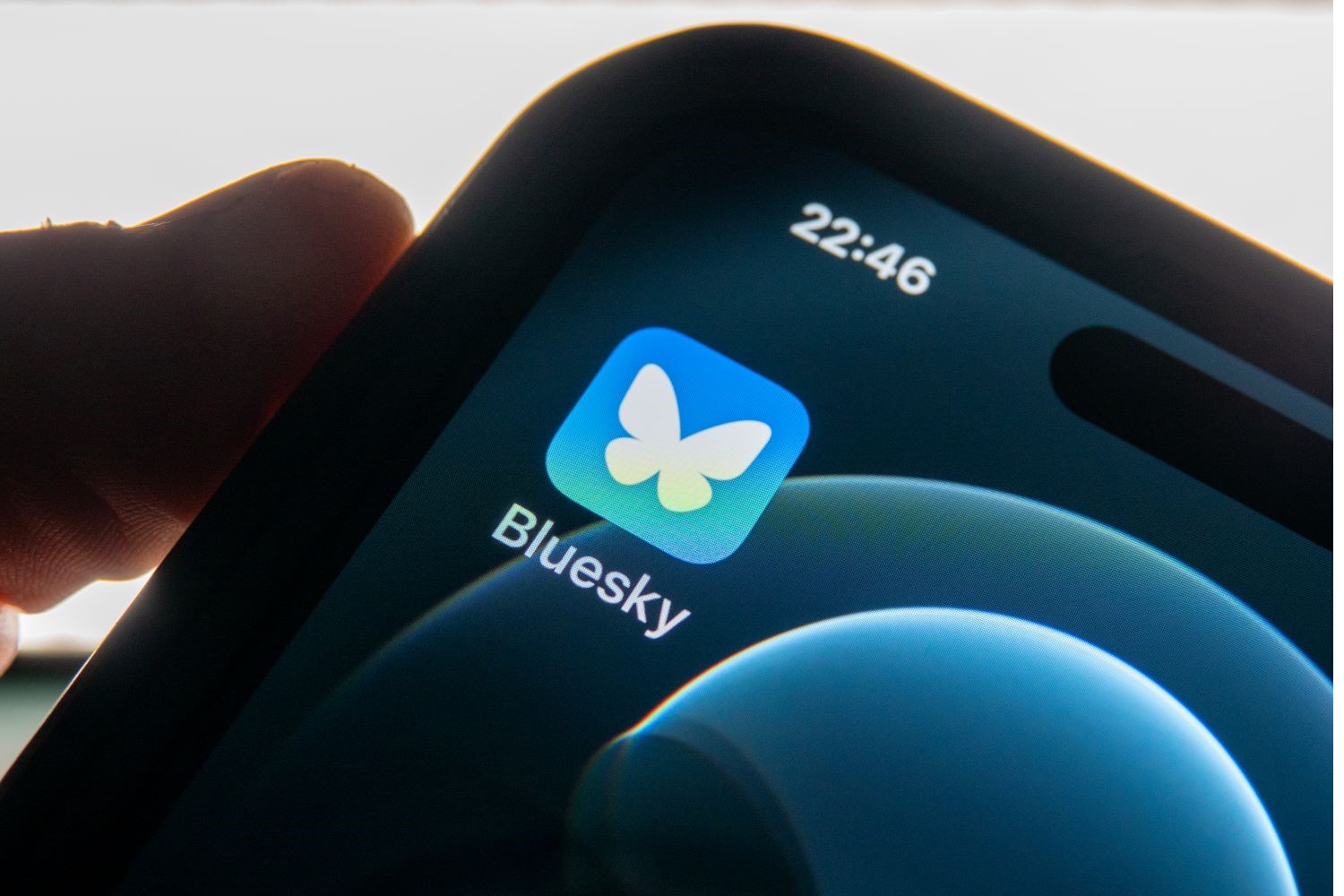 The Bluesky app icon on a phone