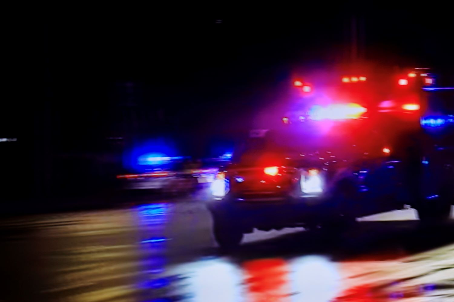 A blurry photo of a police car with its lights flashing.