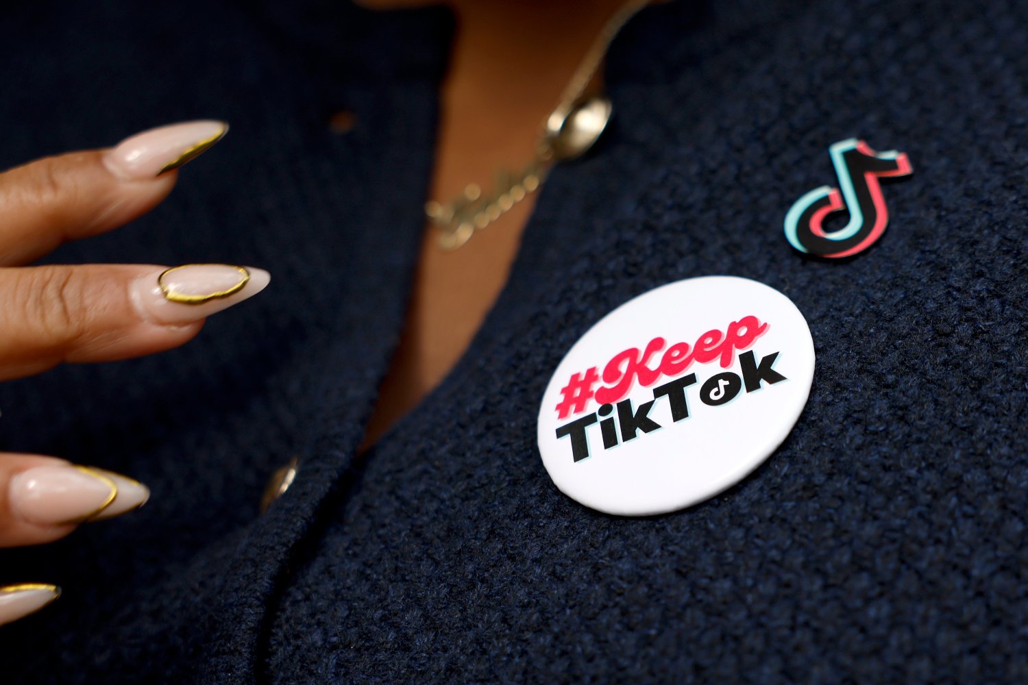 TikTok creator and advocate wearing a button showing support for TikTok on suit jacket