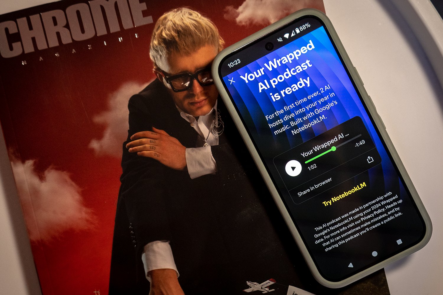 A photo of the Spotify Wrapped AI podcast on a smartphone screen on top of a magazine about music