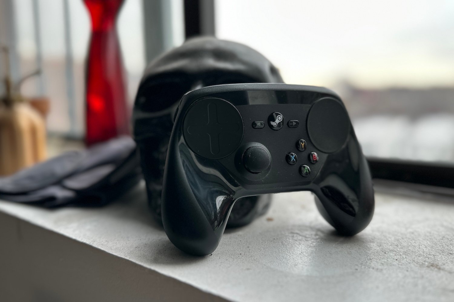 Steam Controller from Valve sitting on a counter next to a skull