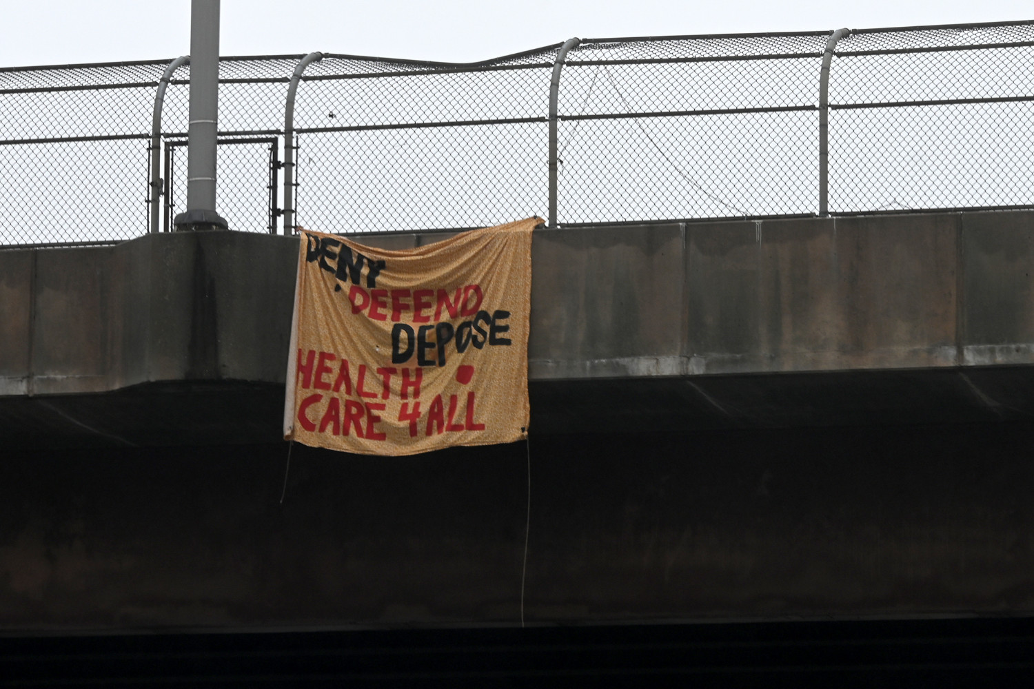 A banner hanging from on overpass along I-83 says, "DENY DEFEND, DEPOSE HEALTH CARE 4 ALL" on Dec. 10, 2024.