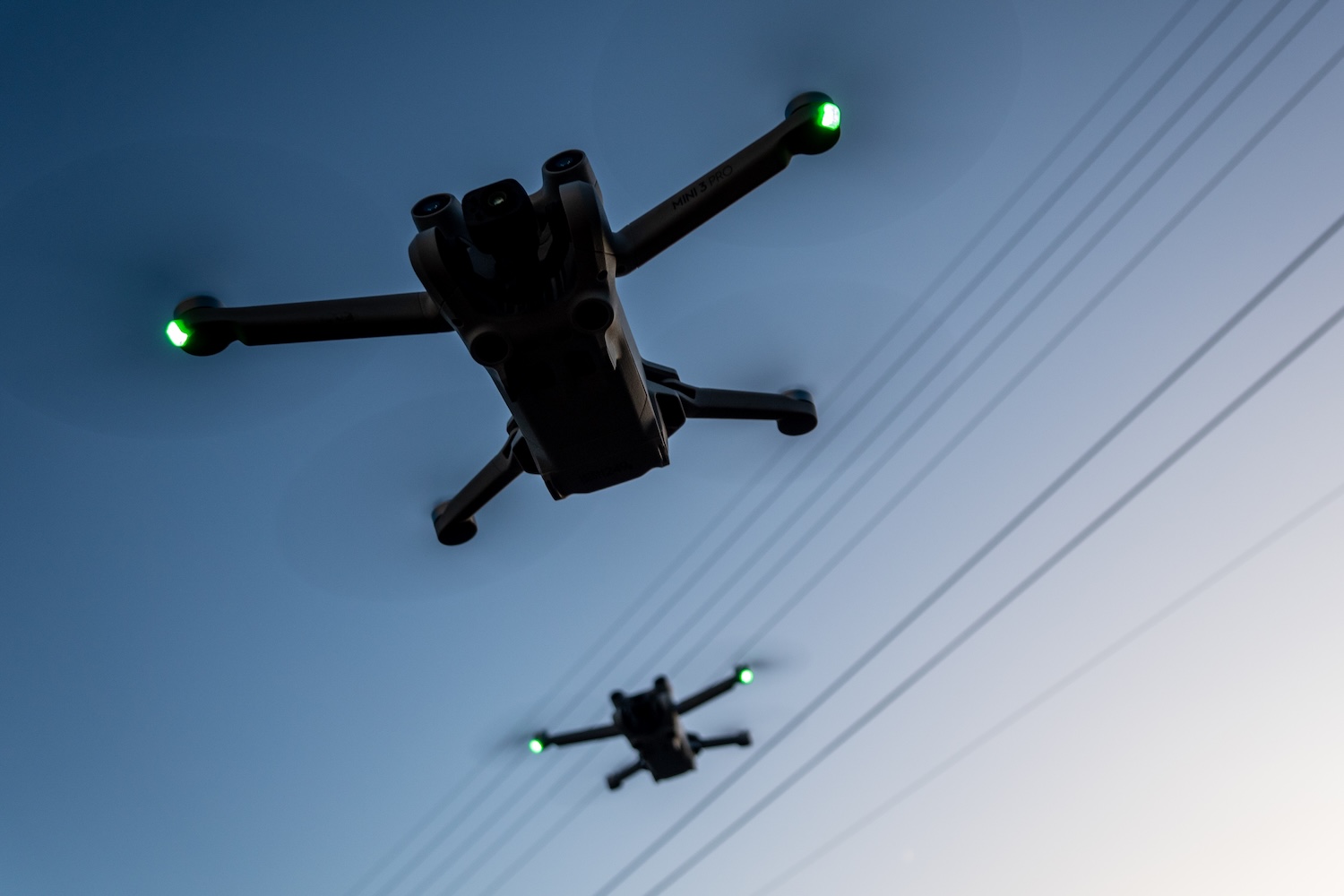 Two DJI drones fly above the ground on January 2, 2025 in Glastonbury, England.