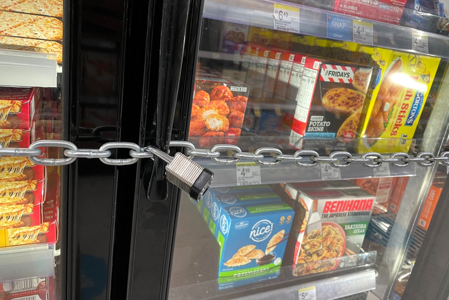 A chain with a padlock in front of freezer doors at a Walgreens store