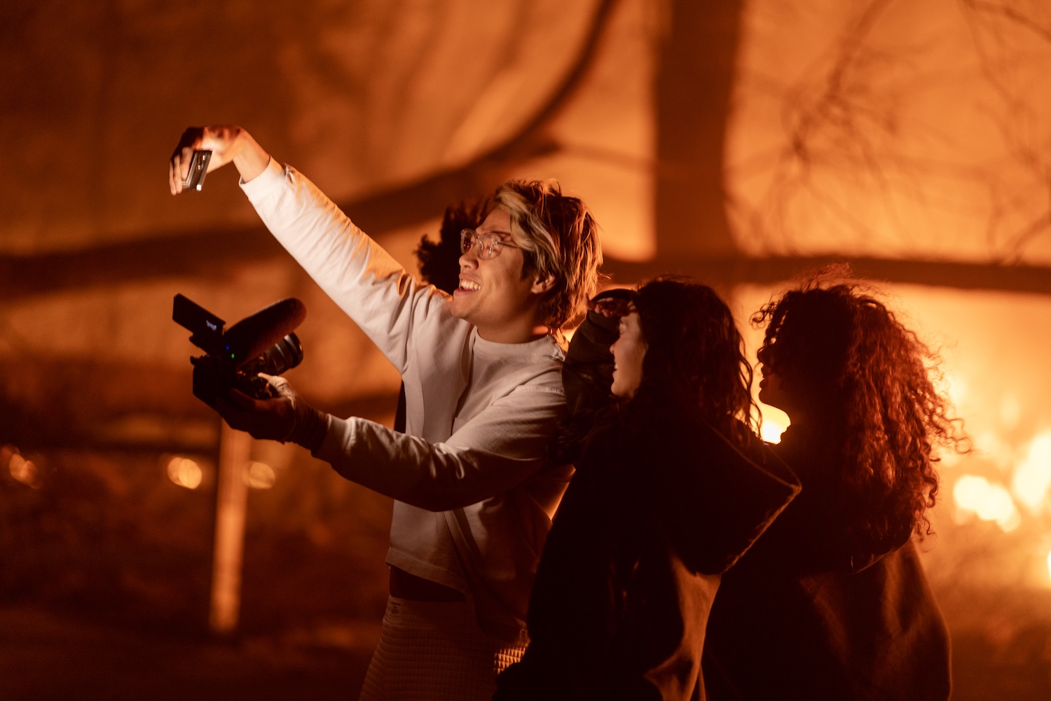 People enter an evacuation zone to take selfie photos and videos near burning homes at the Eaton Fire on January 7, 2025 in Pasadena, California.