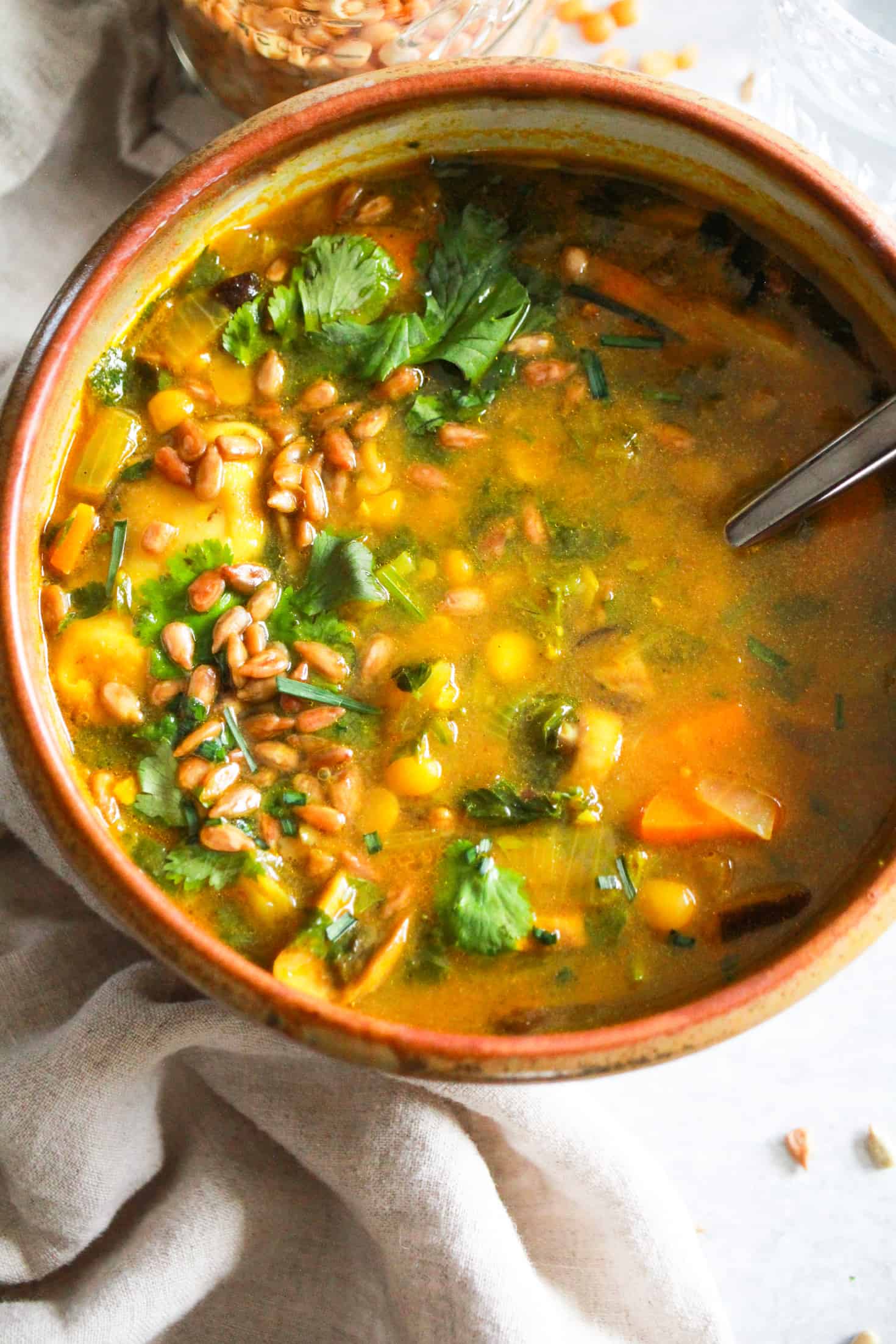 Yellow Split Pea Soup in a brown ceramic bowl with cream linen napkin.