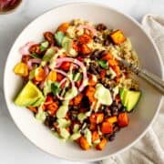 Grain bowl with sweet potato, black beans, quinoa, and avocado dressing.