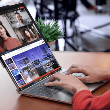 A person types on a laptop. It's screen is extended by a second screen that has been pulled out from the top of the original screen.  