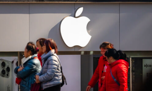 People walking past an Apple logo on a wall in China