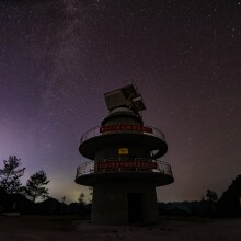 A radio telescope with stars in the background