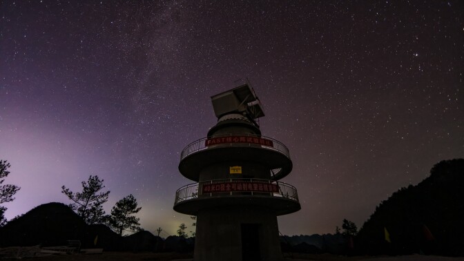 A radio telescope with stars in the background