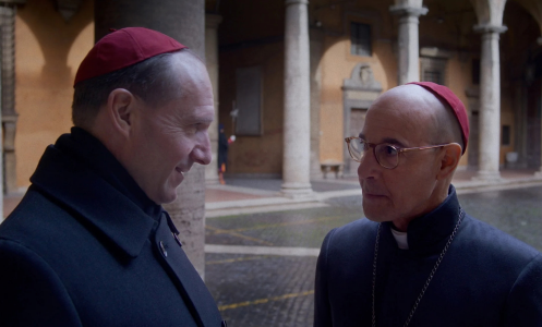 Stanley Tucci and Ralph Fiennes talking in a scene in "Conclave"