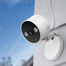 a home security camera on a home's exterior in rainy weather